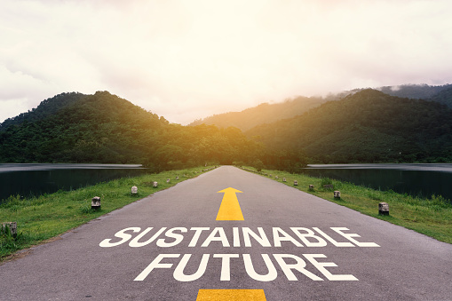 Sustainable future or straightforward concept. Text written on the long road to the green forest. ESG concept, zero-emission, renewable energy, and Sustainable business.
