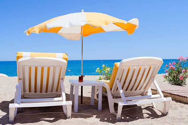 istock two sun loungers and parasol on typical mediterranean beach 182839182