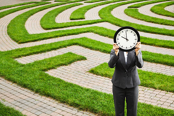 homme d'affaires en face de temps délai, perdu dans le labyrinthe d'emploi - lost in time photos et images de collection