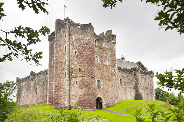 Outside shot of the Doune Castle The 14th century Doune Castle near Stirling, Scotland, seen through trees. circa 14th century photos stock pictures, royalty-free photos & images