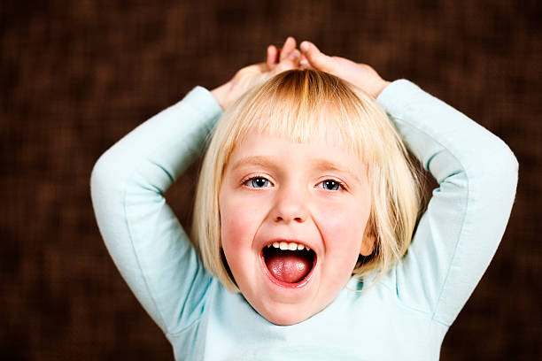 istock Pretty blonde 3 year old looks at camera, mouth open 182840393