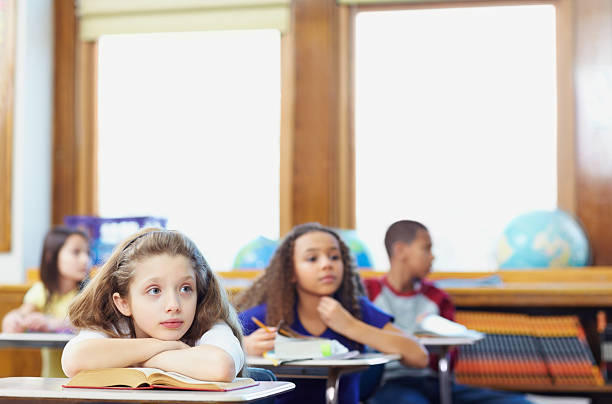 istock Contemplative school children sitting in classroom 182840490