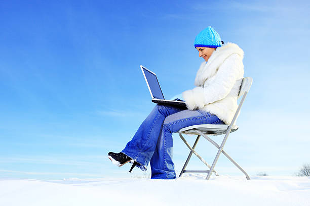 istock Beautiful young girl using a laptop on the snow. 182840497