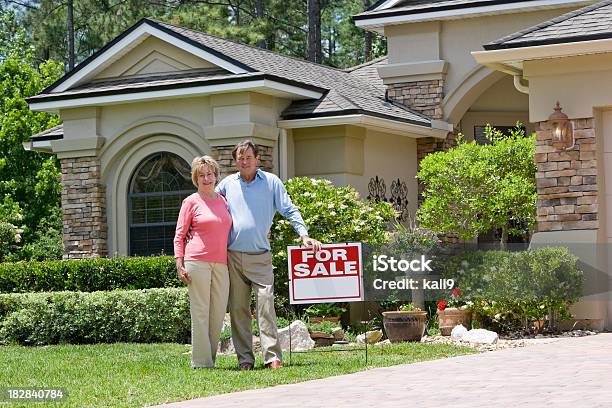 Senior Par De Pie Con Cartel De Venta En Casa Jardín Foto de stock y más banco de imágenes de Tercera edad