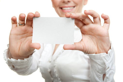 Businesswoman holding blank business card over white background