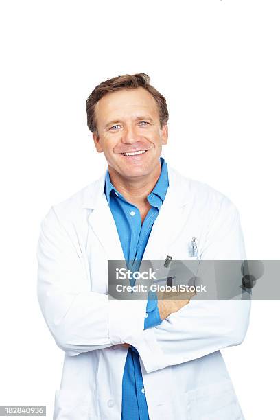 Portrait Of A Smiling Mature Doctor Standing Against White Background Stock Photo - Download Image Now