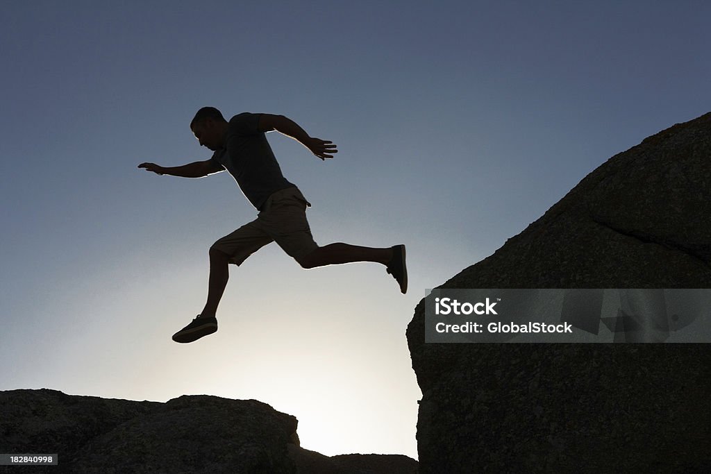 Silhouette-Bild von einem Mann springt von Klippe - Lizenzfrei Abenteuer Stock-Foto