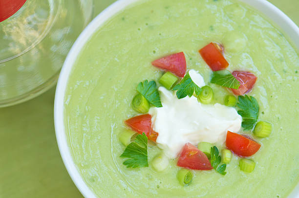 White bowl of cold avocado soup taken from above outdoors