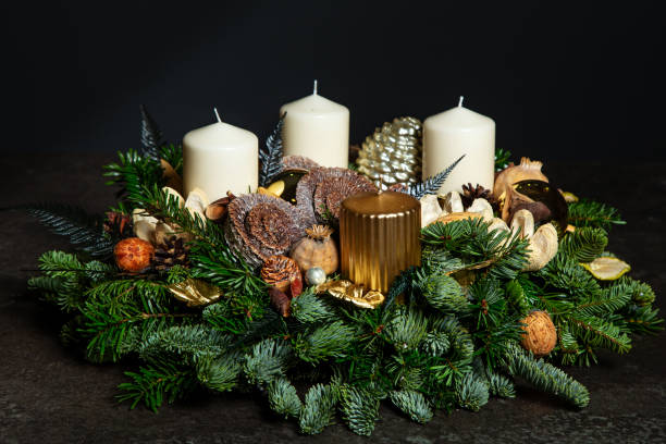 Decorative wreaths of four Advent candles in an Advent wreath decoration on a dark background. tradition before Christmas. Festive still life. Decorative wreath of four white and gold Advent candles in an Advent wreath decoration on a dark background on spruce branches. Tradition before Christmas. Festive still life. advent candle wreath christmas stock pictures, royalty-free photos & images