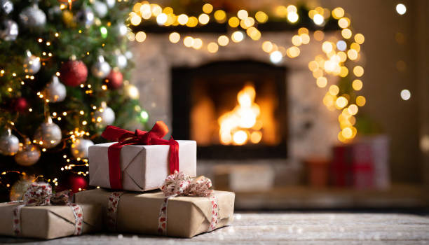 istock Christmas gifts with Christmas tree next to fireplace 1828416104