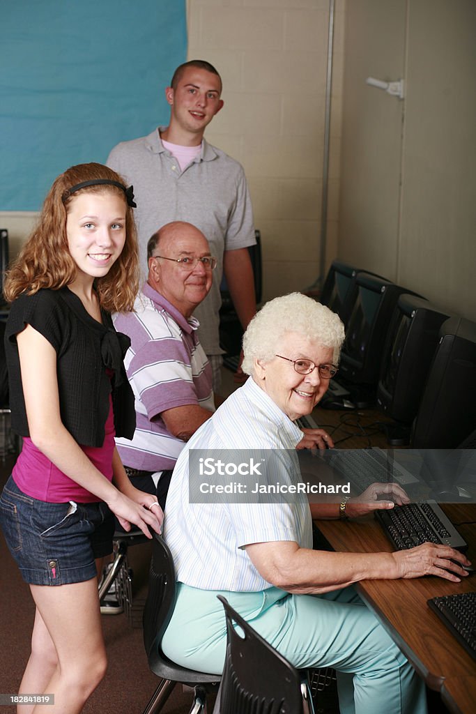 Adolescents et les retraités travaillant dans la Salle des ordinateurs - Photo de 65-69 ans libre de droits