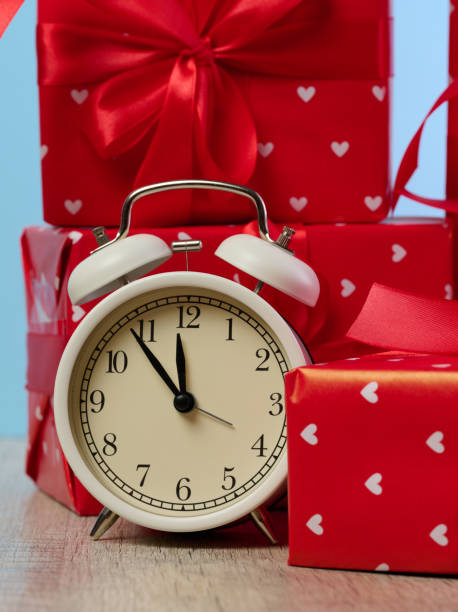 istock Alarm clock and stack of red gift boxes on blue background 1828423548