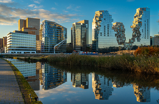 Cityscape of Amsterdam Zuidas, modern office buildings mirrored in the water