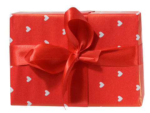 Box is wrapped in red gift wrapping and red ribbon on a white isolated background