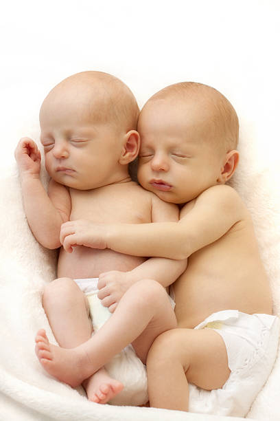 Cute newborn twin sleeping together stock photo