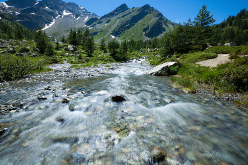 Majestic panorama in the Italian Alps with flowing water in idyllic river.Long time exposure obtained with ND filter and 50 ISO.