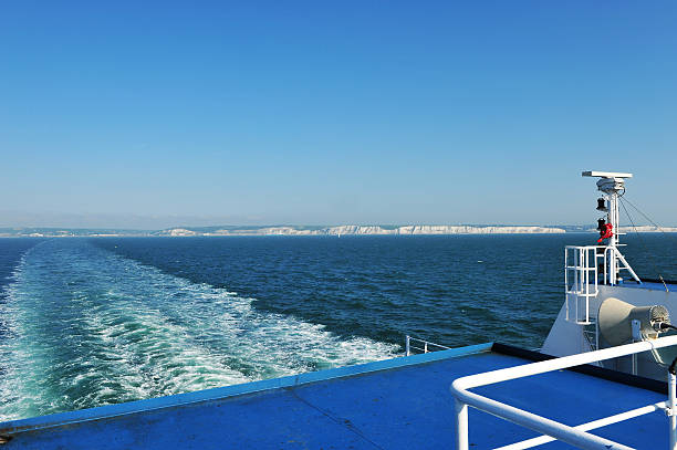 View from a car ferry sailing between England and France View from the rear of a car ferry as it sails across the English Channel between Dover, England and Calais, France.   The White Cliffs of Dover can be seen lining the coastline of England. ferry dover england calais france uk stock pictures, royalty-free photos & images