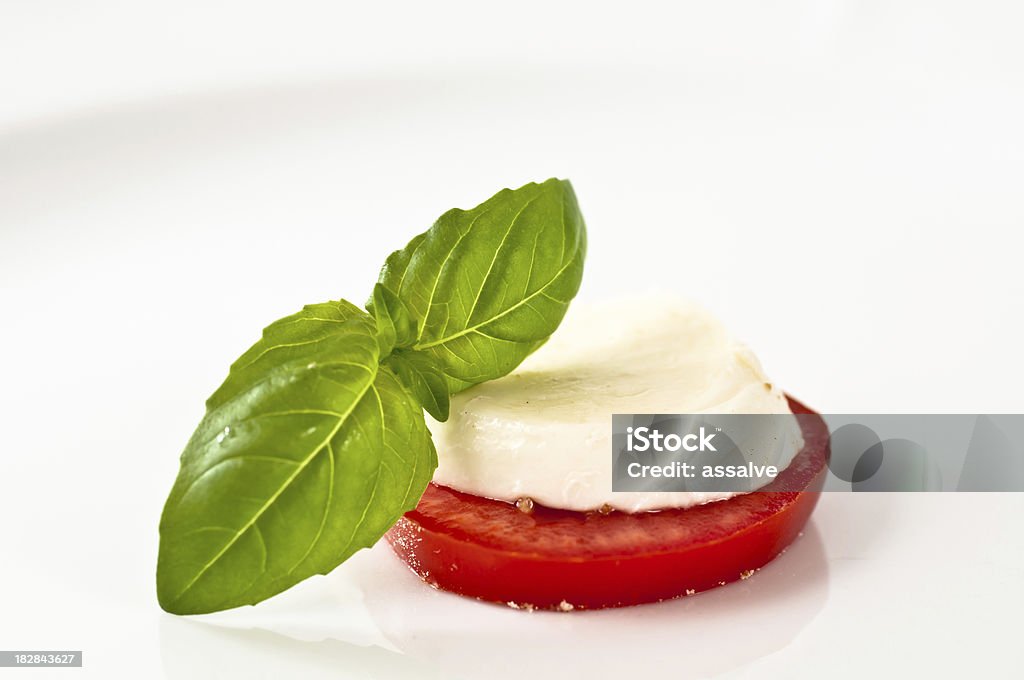 Fette di pomodoro e mozzarella e basilico - Foto stock royalty-free di Mozzarella