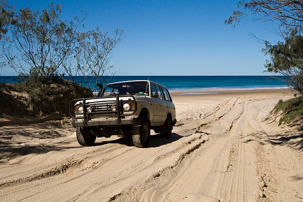 Fraser Island 4WD A 4WD tackling the sandy track around Indian Head on Fraser Island in Queensland. fraser island stock pictures, royalty-free photos & images