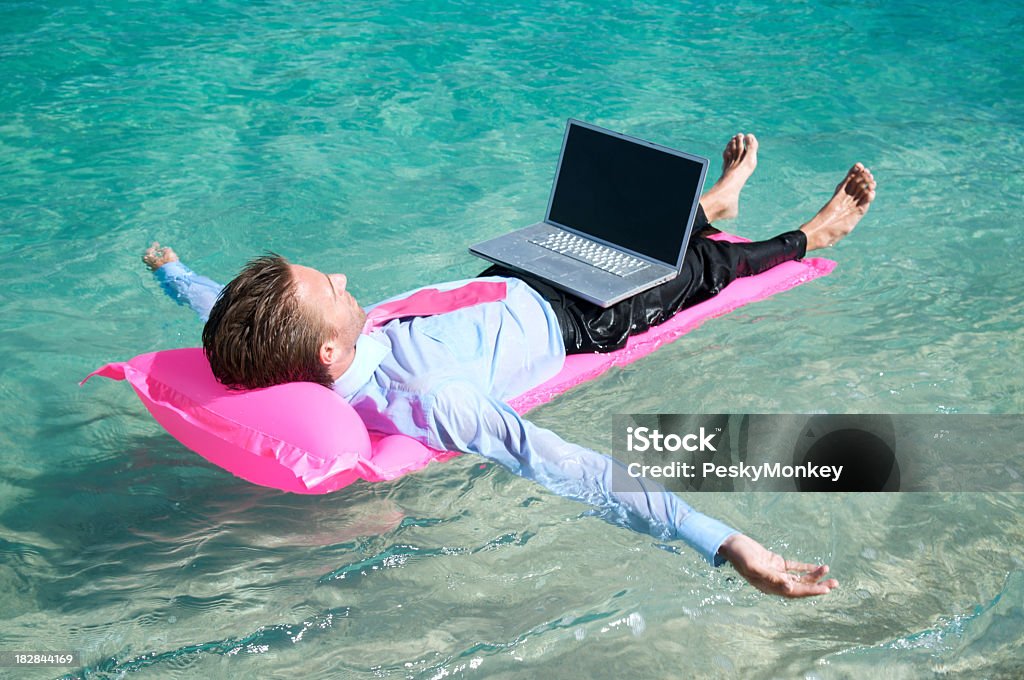 Zrelaksowany Biznesmen pływające z laptopa na Różowe Materac dmuchany - Zbiór zdjęć royalty-free (Internet)
