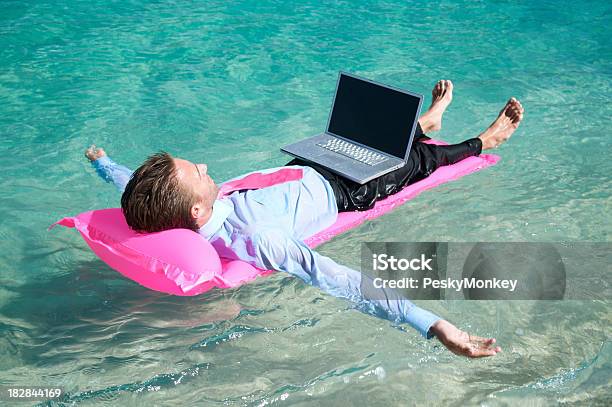 Zrelaksowany Biznesmen Pływające Z Laptopa Na Różowe Materac Dmuchany - zdjęcia stockowe i więcej obrazów Internet