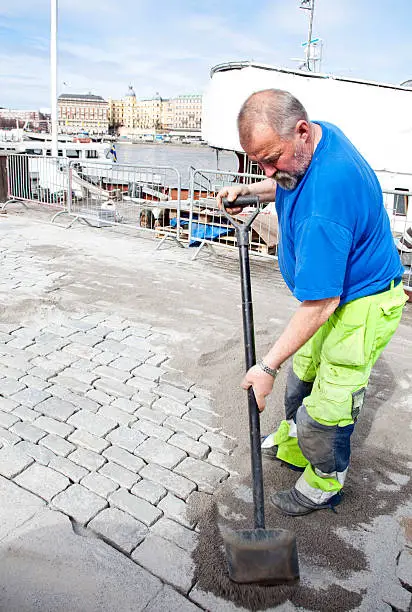 "Elderly paver spreading sand over new set paving stones, Stockholm, SwedenSee also my LB:"