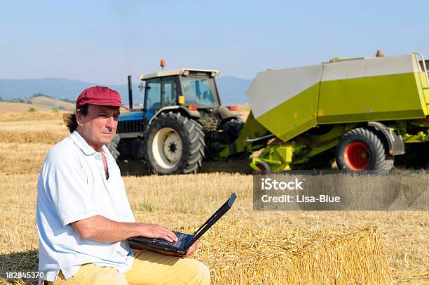 Photo libre de droit de Longue Agriculteur Avec Un Ordinateur Portable Dans Un Champ De Blé banque d'images et plus d'images libres de droit de 45-49 ans