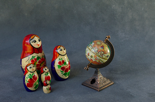 A set of bright red wooden lacquered nesting dolls on a white wooden table close up