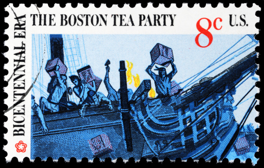 Boston Tea Party.  Eight cent cancelled US postage stamp with postmark. Stamp features a detail from scene of Boston Tea Party in which American colonists threw crates of British tea off of a vessel in Boston harbor in defiance of British taxation.