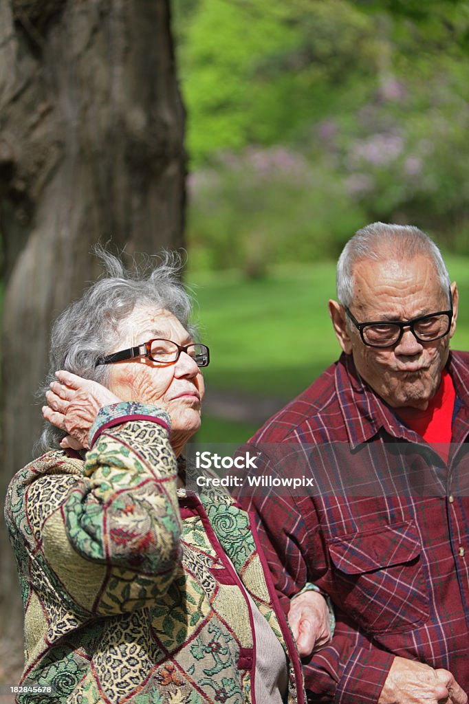 Senior Man and Woman Funny Faces A senior couple making funny faces for the camera - Grandpa is supporting Grandma as they walk together on a trail at a nature park. Selective focus on woman's face with copy space above. 80-89 Years Stock Photo