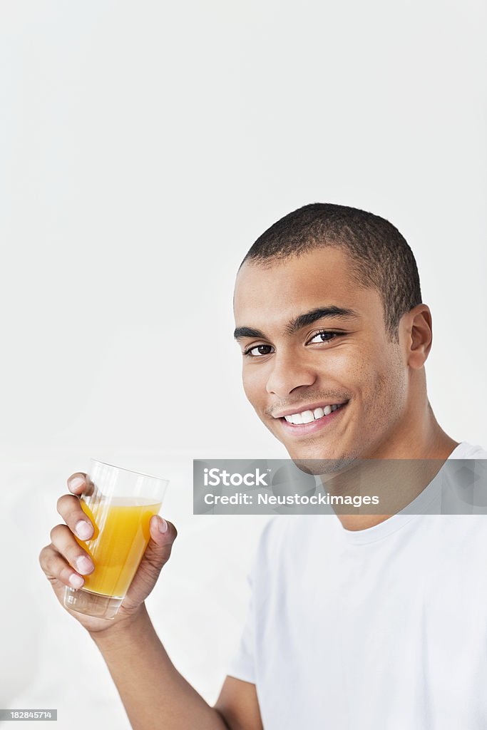 젊은 남자 술마시기 오렌지 주스 - 로열티 프리 남자 스톡 사진
