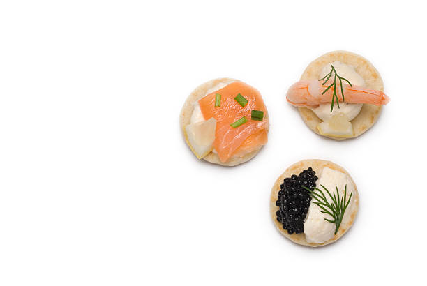 Three bite sized appetizers A studio shot of a selection of three bite sized canapes isolated on a white background. The canapés contain smoked salmon, prawn and caviar with a dill and chive garnish blini photos stock pictures, royalty-free photos & images