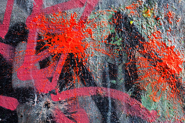 Dirty grey concrete wall with pink spray paint marks. Background and wallpaper grunge texture.