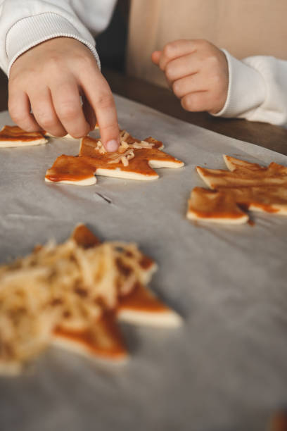 istock Child making pizza in the shape of a Christmas tree, activity idea 1828466891