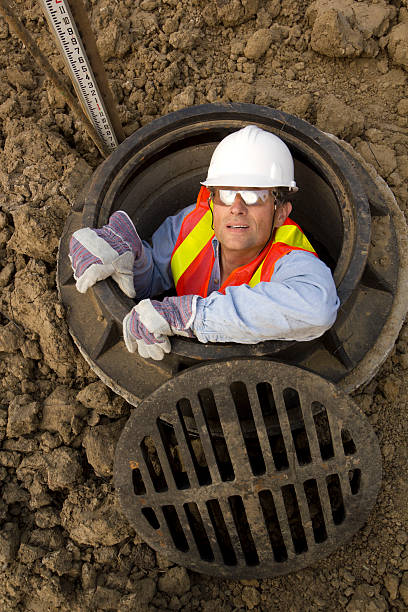 In the Sewer A city maintainance worker in a sewer. manhole stock pictures, royalty-free photos & images