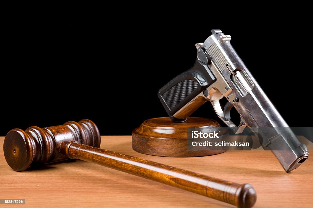Hölzerne Richterhammer und die Pistole an einem Tisch für Crime Punishment Konzept - Lizenzfrei Schusswaffe Stock-Foto