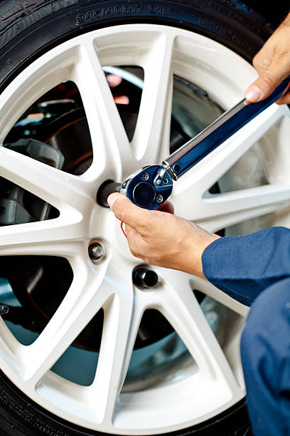 istock mechanic putting lugnut on wheel 182848059