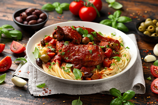 Cacciatore Chicken with spaghetti, vegetables, olives and tomatoes.