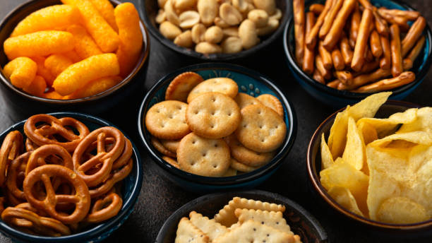 istock Salty snacks crackers, potato chips, pretzel, peanuts, corn puffs. 1828491365