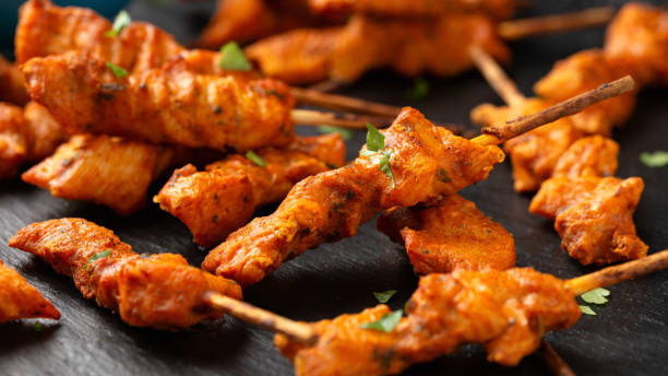 istock Grilled chicken fillet on skewers with white sauce on rustic stone board 1828492167