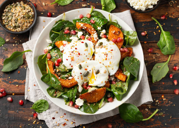 istock Roasted butternut squash salad served with poached eggs, spinach, nuts and pomegranate seeds 1828492440