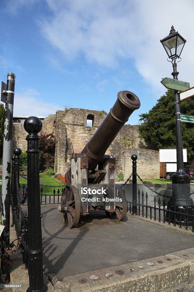 ancient cannon guards medieval castle ruin in Ludlow, England, an ancient cannon guards medieval castle ruins against a summer blue sky Blue Stock Photo