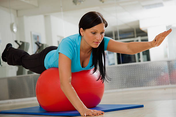 woman performing opposite arm and leg swissball exercise ripl fitness
