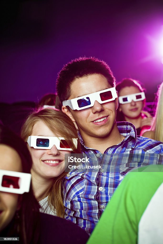 Date in 3D movie theater Young adult couples wearing 3D glasses sitting in the cinema and watching 3D movie. They smiling and having fun. 3-D Glasses Stock Photo