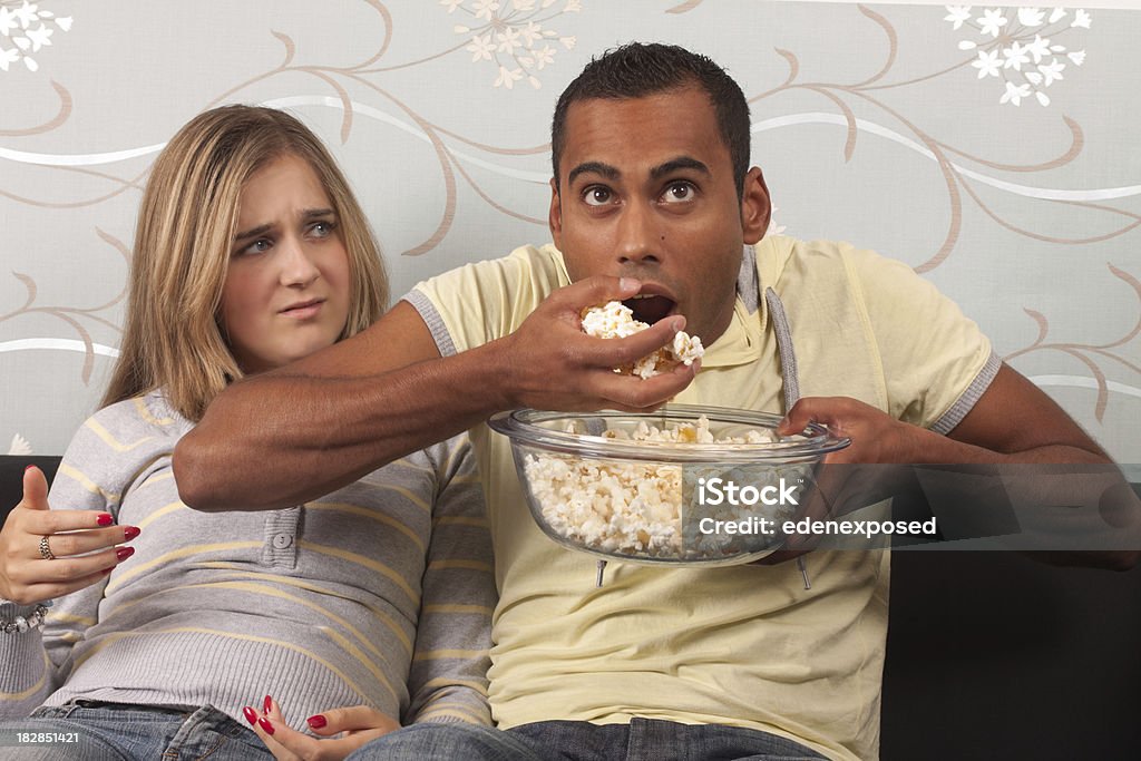 Hombre comiendo palomitas de maíz - Foto de stock de 20 a 29 años libre de derechos