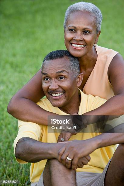 Szczęśliwy Starszy African American Para Siedzi Na Trawie Razem - zdjęcia stockowe i więcej obrazów Afroamerykanin