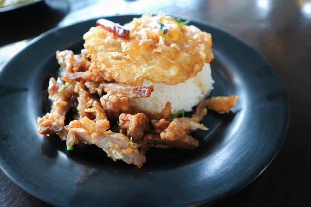 rice topped with sunny side up egg or fried egg and fried pork
