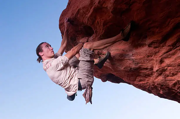 A young man demonstrates his rock climbing technique.