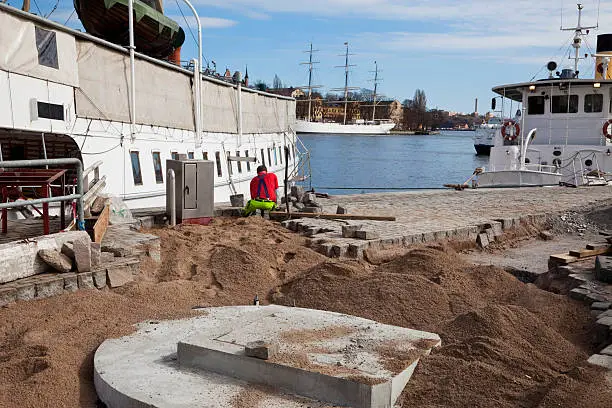 "Paver working on his knees setting granite paving stones, Stockholm, Sweden. Old sailing ship and steamers in the backgroundSee also my LB:"