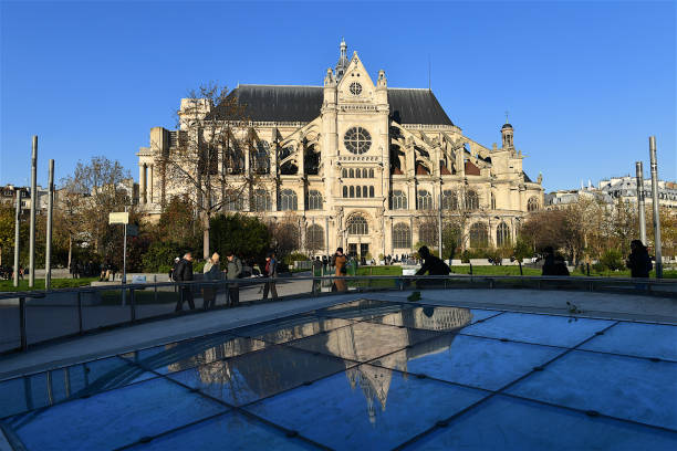 The Saint-Eustache church, Paris, France. Paris, France-12 02 2023: Group of people in a park passing the Saint-Eustache church in Les Halles district of Paris, France. église saint eustache stock pictures, royalty-free photos & images